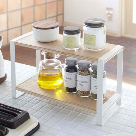 a tiny white and natural wood spice rack is a great kitchen storage solution on a budget