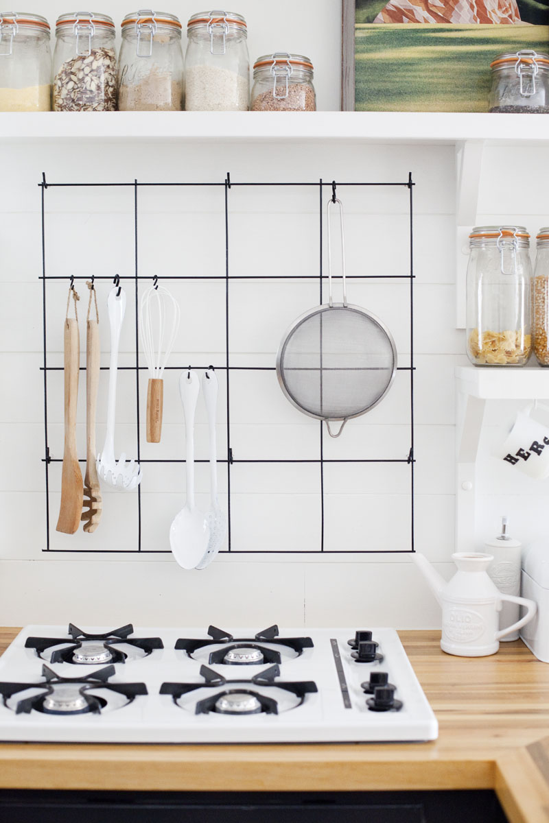 cheap kitchen organization: hang a wire rack above the stove to store cooking supplies