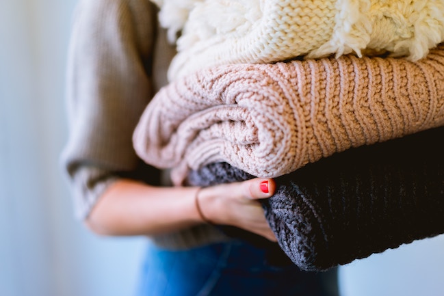 woman holding winter clothes