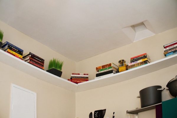 bedroom storage shelves installed along the perimeter of a wall