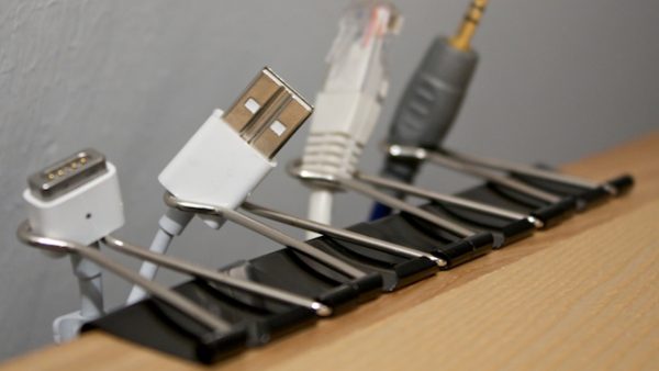 Cord storage hack: clip binder clips onto a desk and store cords in the clips' loops.