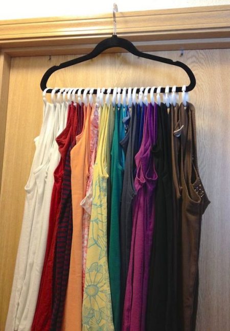 tank top storage hack: attach shower curtain rings to a hanger and hang it on top of a bedroom door