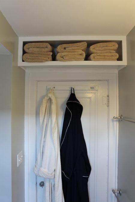 white diy storage shelf above a bathroom door