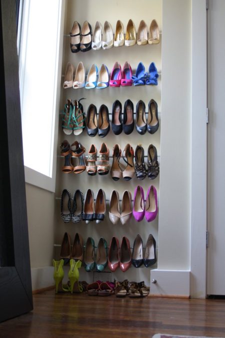 tension rod shoe racks installed in a small bedroom nook