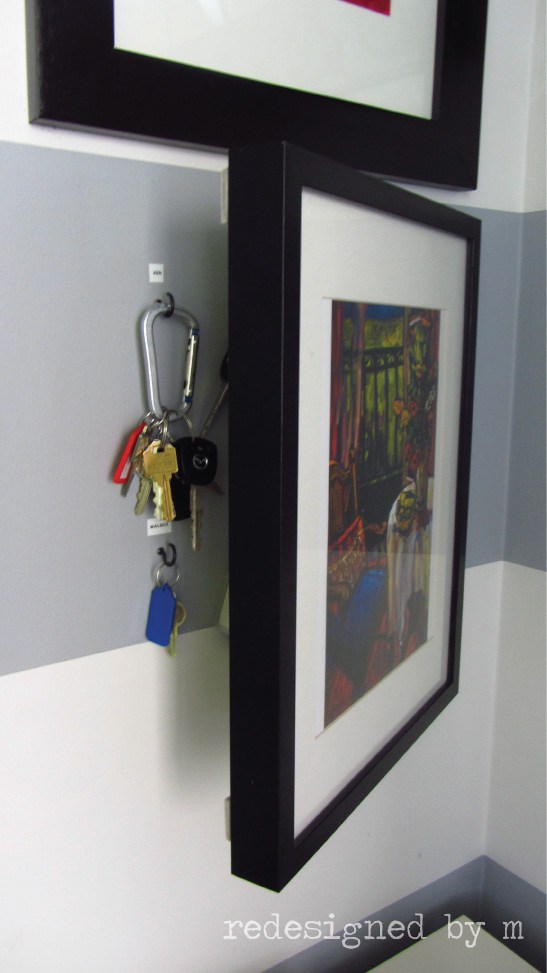 hidden key holder picture frame mounted on an entryway wall
