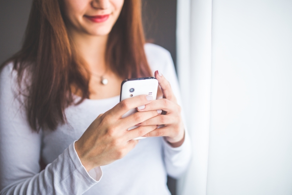 young woman texting on an android phone