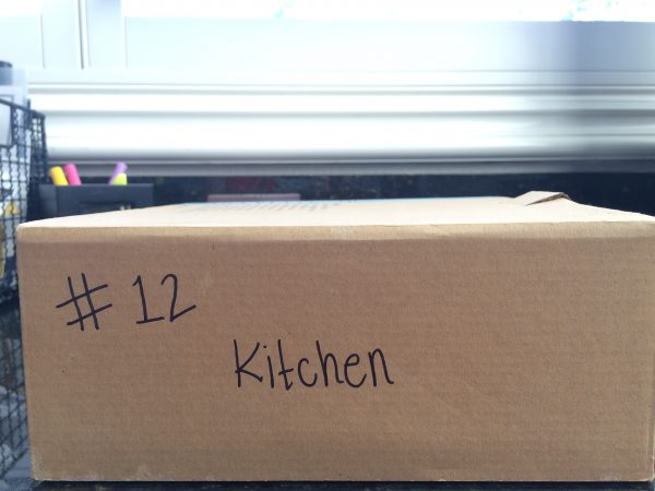 a cardboard moving box with "#12" and "kitchen" written on the side