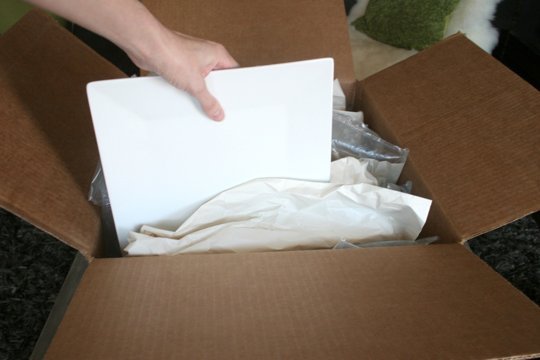 pack dishes vertically in a box for moving and protect them with packing paper and bubble wrap