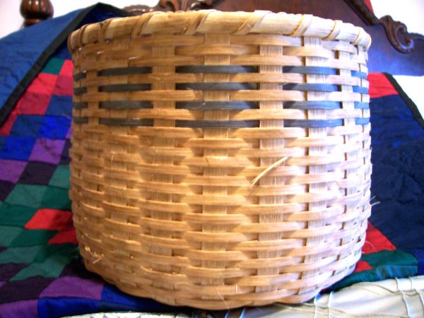 woven basket for storage on a checkered blanket in a bedroom