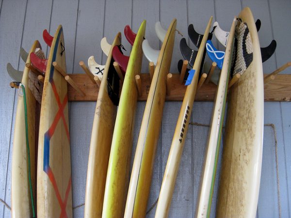 A wooden vertical surfboard rack storing 8 surfboards