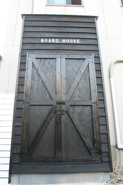The exterior of a wooden surf shed painted in black