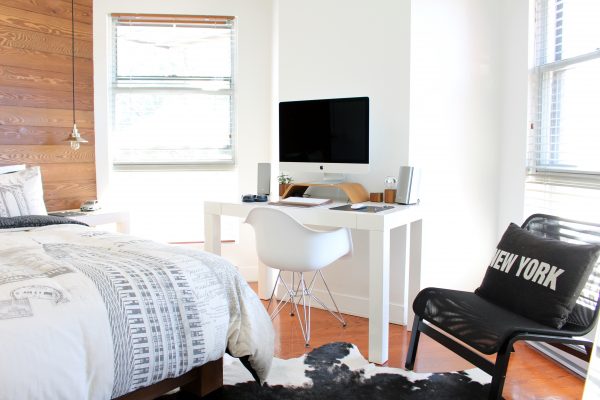 clean bedroom, desk, table, chair, new york pillow, and cowhide rug
