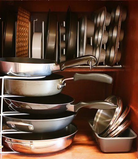 kitchen cabinet organizers storing pans, muffin trays, cake pans, baking sheets, and cookie sheets