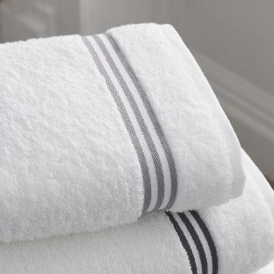 stack of folded 2 clean white bathroom towels with stripes