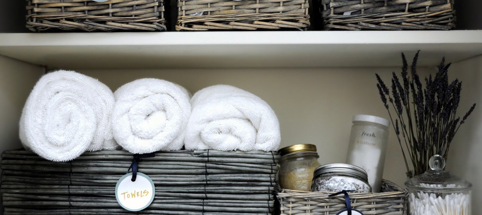 how to organize linen closet: declutter, sort by category, and store things in storage baskets with labels
