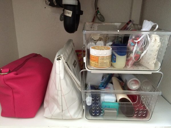 clear stackable drawers organize beauty products under a sink