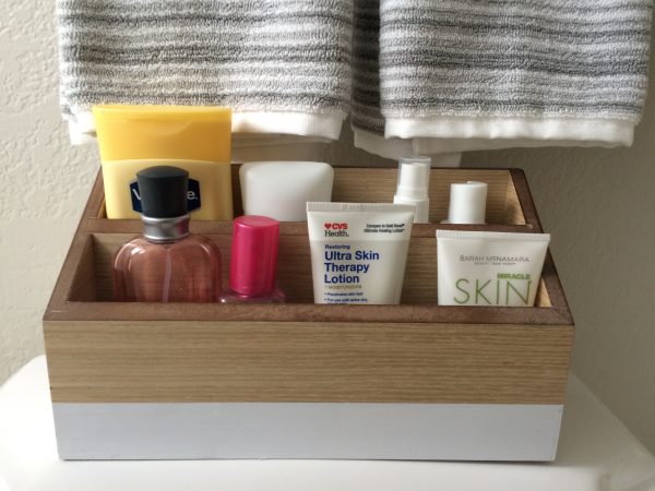 diy beauty product storage desk organizer on top of a toilet tank cover in a bathroom 