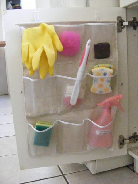 diy pocket organizer hanging on a cabinet door and storing cleaning supplies