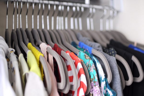 shirts hanging on gray felt hangers in an organized closet