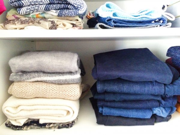 denim and sweaters stacked on closet shelves