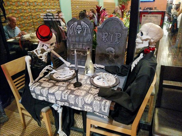 halloween skeletons sitting at a dining table