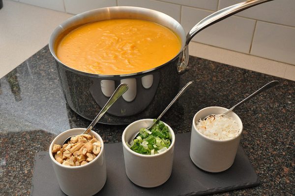 roasted butternut squash soup in a pot next to condiments on a kitchen counter
