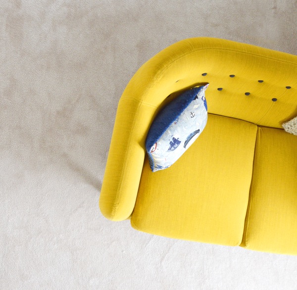 throw pillow on a yellow futon in a living room