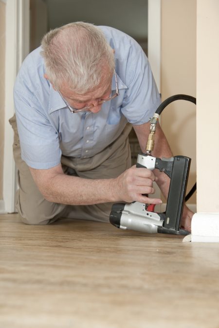 man repairing baseboards