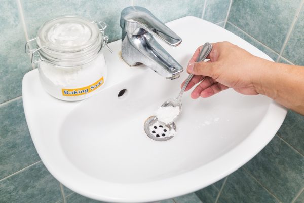 a person fixing a clogged sink in a bathroom