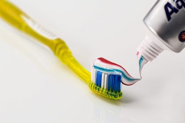 squeezing toothpaste onto a toothbrush