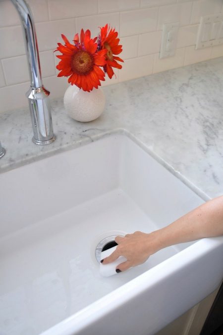 scrubbing a white kitchen sink with an hdx easy eraser