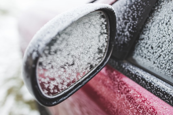 snow on the driver's side sideview mirror and window