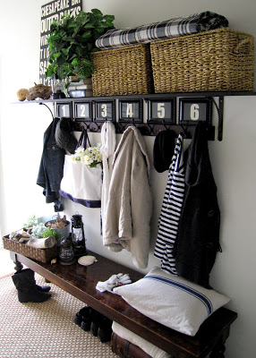 entryway bench with numbered coat hooks, a shelf, and baskets for storage