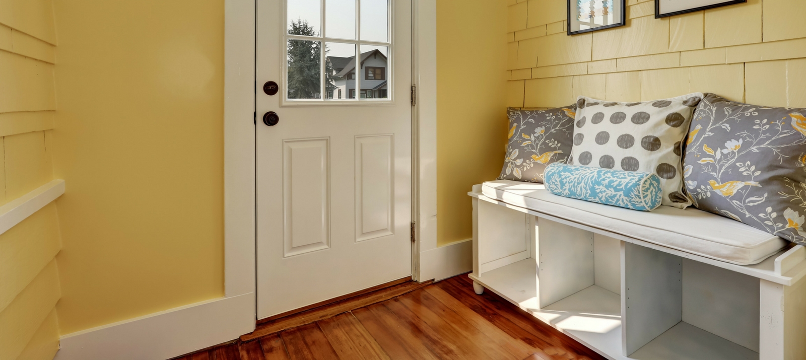 entryway storage hacks, ideas, and solutions: white storage bench with cubbies, wheels, a cushion, and pillows