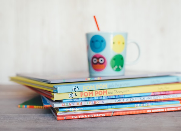 kids mug atop a stack of children's books