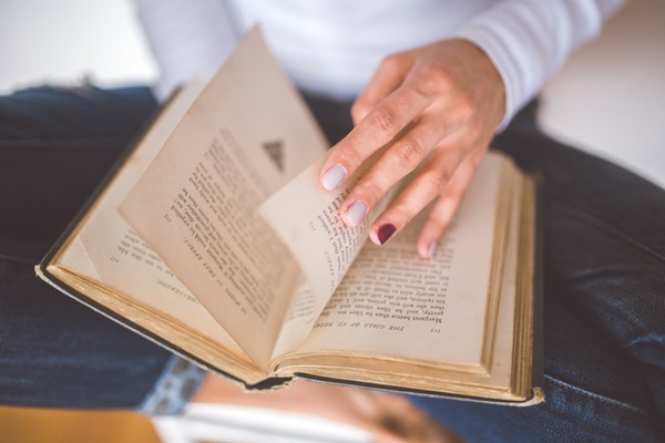 a woman thumbing through an old book