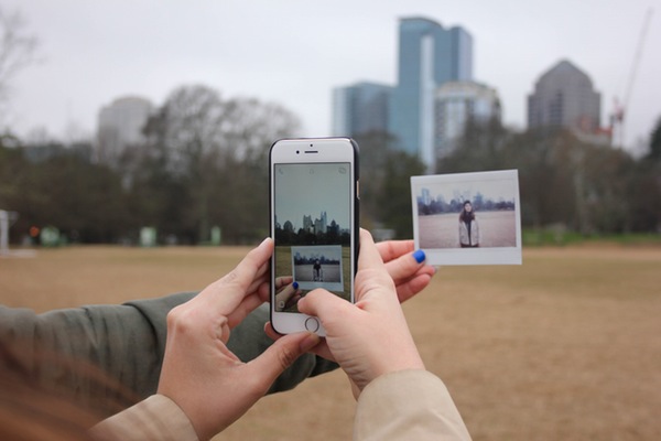 hands using an iPhone to take a picture of a photo