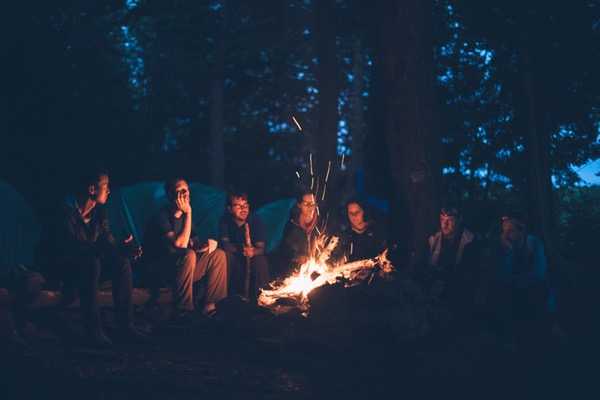 people sitting in front of a bonfire