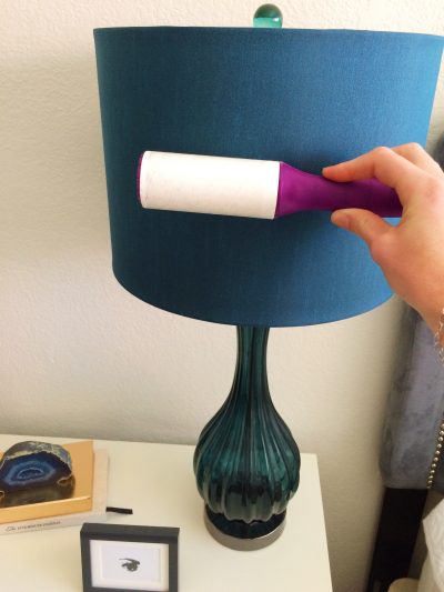 paige smith is cleaning a lampshade with a lint roller