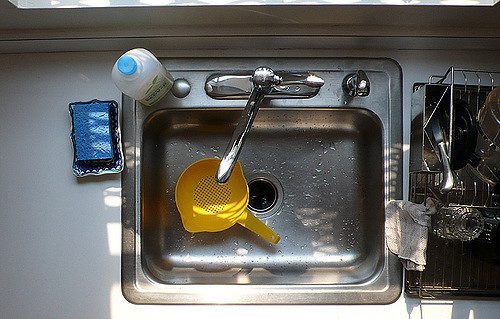 a yellow strainer in a clean kitchen sink