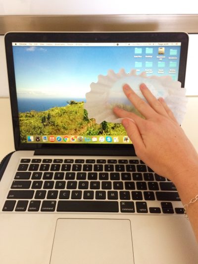 paige smith cleaning a computer screen with a coffee filter