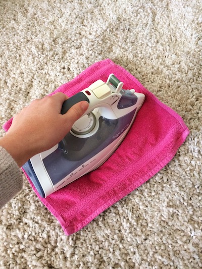 paige smith removing carpet stains with an iron and wet pink towel