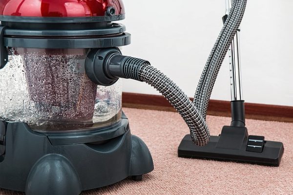 red and black hoover vacuum cleaner on a carpet