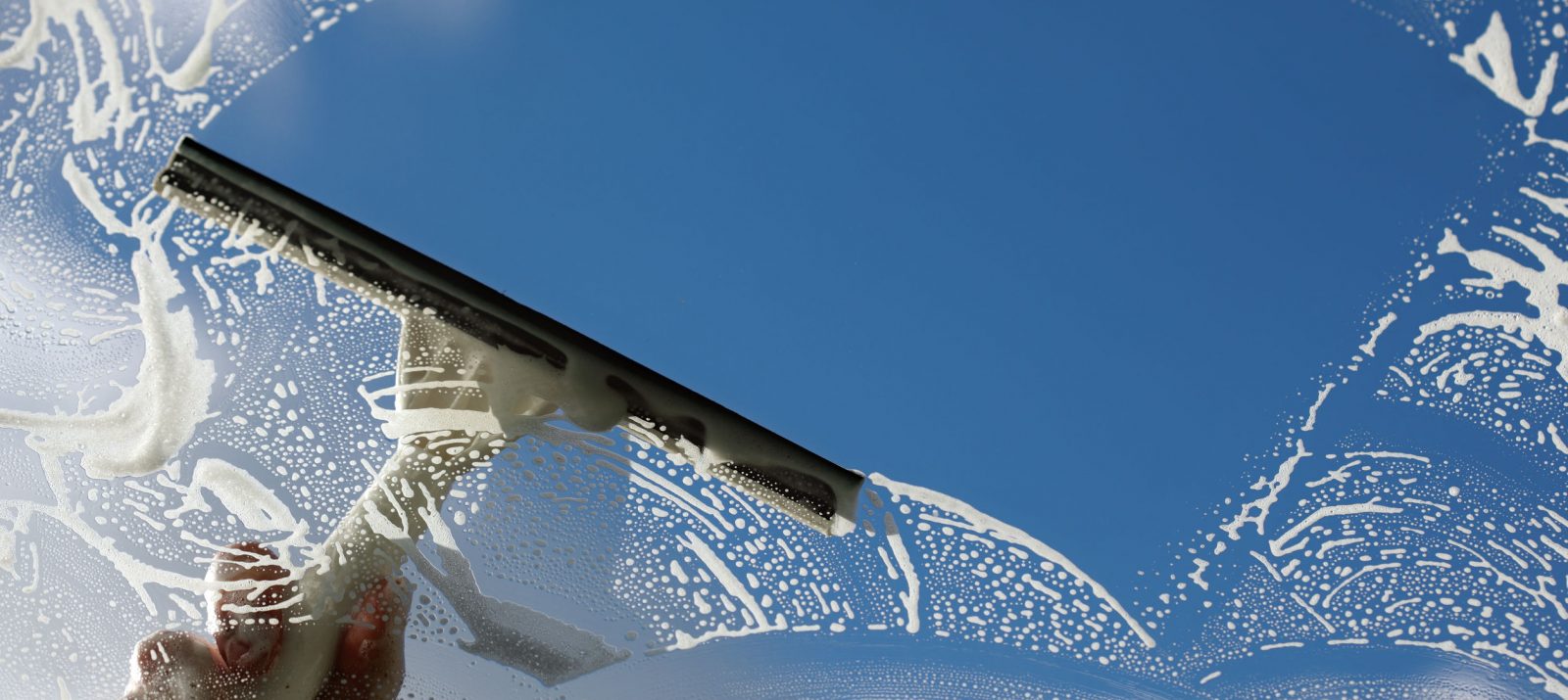 using a squeegee to wash a window