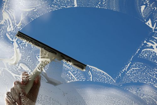 using a squeegee to wash a window