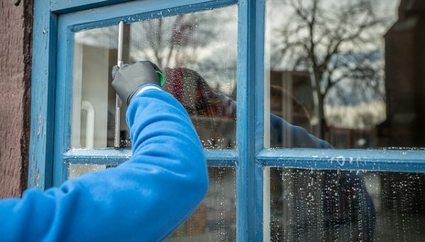 cleaning the outside-facing part of a window with a squeegee