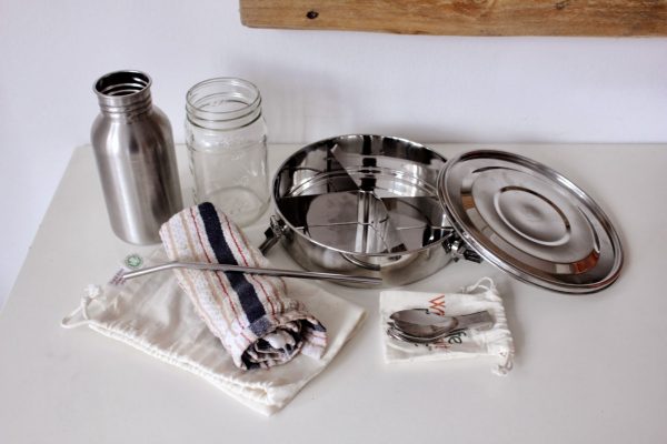 zero waste lunch kit by trash is for tossers includes: a stainless steel lunch container, a reusable fork and napkin, organic cotton bags, a mason jar, and a stainless steel canteen