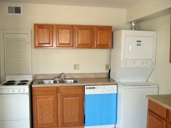stove, sink, dish washer, and an all-ine-one washer dryer crammed next to each other in a small kitchen