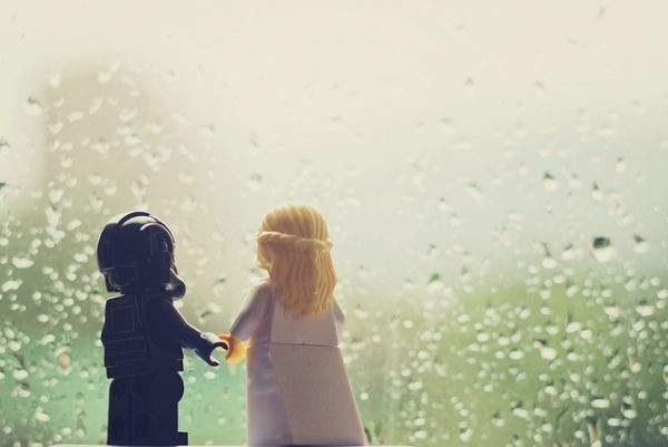 lego star wars characters holding hands and looking through a window on a rainy day