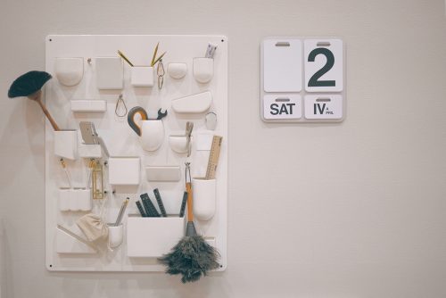 white wall organizers and a wall-mounted calendar with large numbers and letters